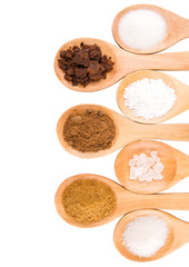 Various type of sugar on wooden spoon over white background