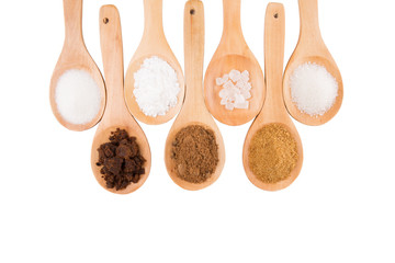 Various type of sugar on wooden spoon over white background