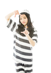 Young Asian woman making frame with fingers in prisoners uniform