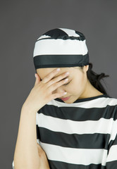 Upset young Asian woman with her head in hands in prisoners