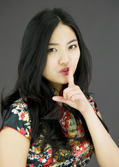 Asian young woman with finger on lips