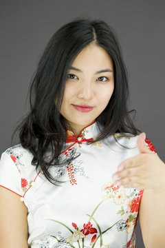 Asian young woman giving hand for handshake isolated on colored