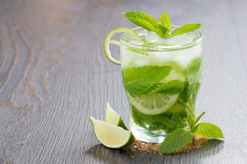 mojito cocktail with lime and mint on wooden table