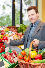 Mann kauft Gemüse im Biomarkt