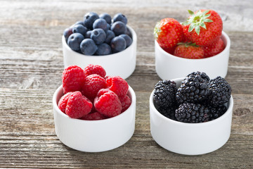 raspberries, blackberries, strawberries and blueberries in bowls