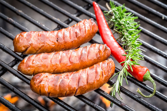 Hot sausage on the grill with chilli and rosemary