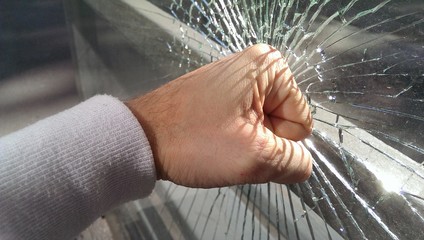 Male fist and broken glass with cracks