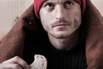Homeless man eating a piece of bread