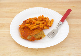 TV dinner of breaded chicken and pasta on paper plate