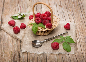 Sweet raspberries in basket  on the wooden table