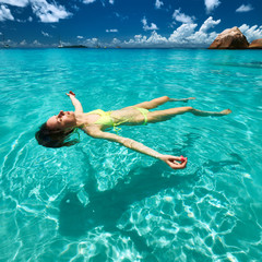 Woman in bikini lying on water