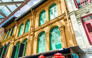 Naklejka premium Closed colorful window shutters in Chinatown district of Singapo