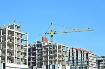 Crane and building construction site against blue sky