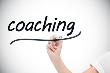 Businesswoman writing the word coaching