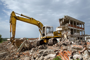 Bulldozer removes the debris from demolition of old buildings