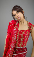 Young Indian woman sticking out her tongue