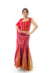 Confident Indian young woman standing with arms akimbo