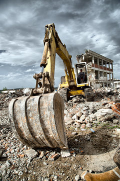 Bulldozer removes the debris from demolition of old buildings