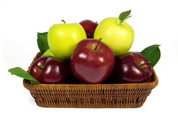 Fresh red and green apples with leaves in wicker basket isolated