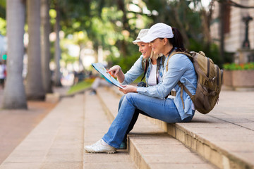 young female tourists looking at map