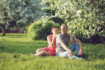 Young Couple in Love among Trees in Blossom