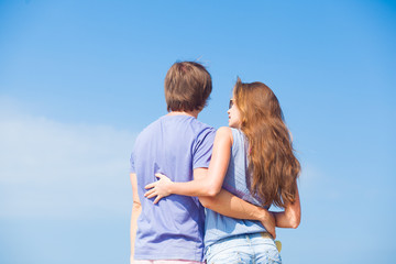 Obraz premium back view of couple hugging outdoors at beach