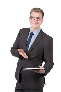 Junger l&auml;chelnder Mann pr&auml;sentiert ein Tablet