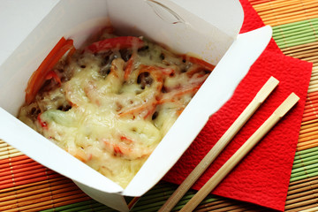 Noodles with cheese and vegetables in take-out box