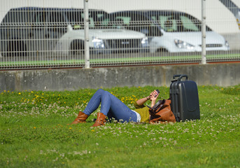 woman resting with her suitcase and using your smartphone