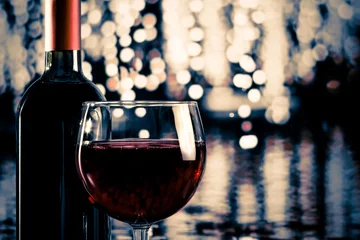 Papier Peint photo Vin red wine glass near bottle with light bokeh