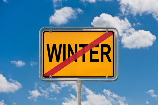 Ortsschild - Winter - durchgestrichen vor blauem Wolkenhimmel