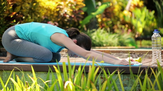 Woman stretching, doing japanese sit in the garden