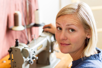 Pretty Blonde Woman At Sewing Machine