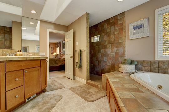 Spacious bathroom with corner bath tub and open shower