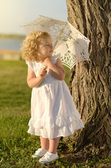 Young beautiful girl posing for the camera in white dress