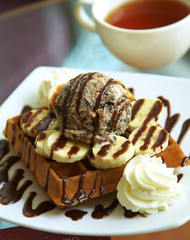 close up chocolate waffle and banana with sweet sauce