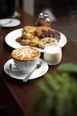 close up hot latte and milk on wooden table