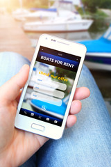 mobile phone with boats for rent offer holded by hand