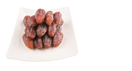 Date fruits on a white plate