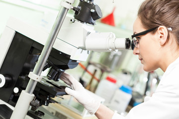 Woman using microscope during working in laboratory