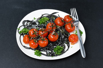 black spaghetti with baked tomatoes, parmesan cheese