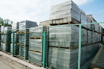 Packed cinder blocks outdoors in racks.