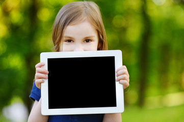 Happy child holding tablet PC outdoors