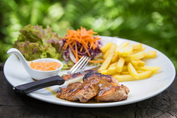 juicy grilled pork chop (neck cut) with greens