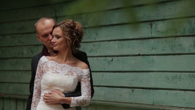 Beautiful wedding couple near a blue wall