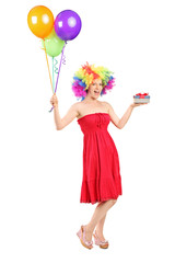 Woman wearing a wig and holding present and balloons