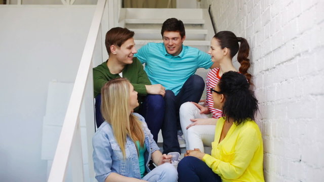 smiling students sitting on stairs and talking