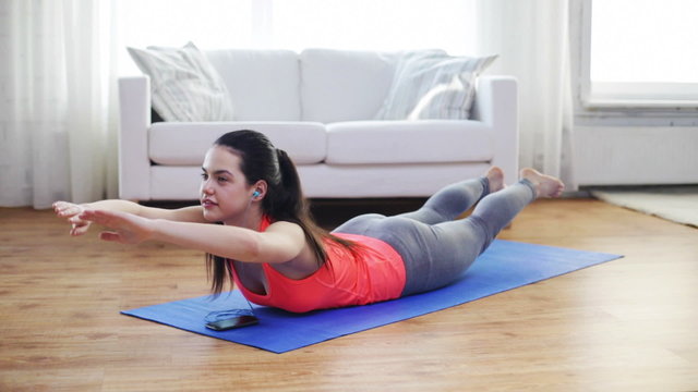 smiling woman with smartphone exercising at home