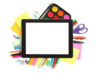 Tablet PC with school office supplies on white background.