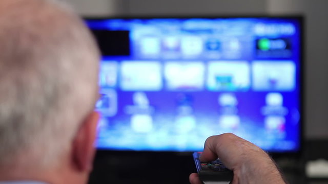 Smart tv and senior man hand pressing remote control